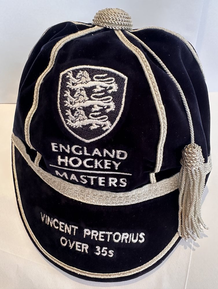 The cap from a three-quarter angle, showing the panels, braid and tassel