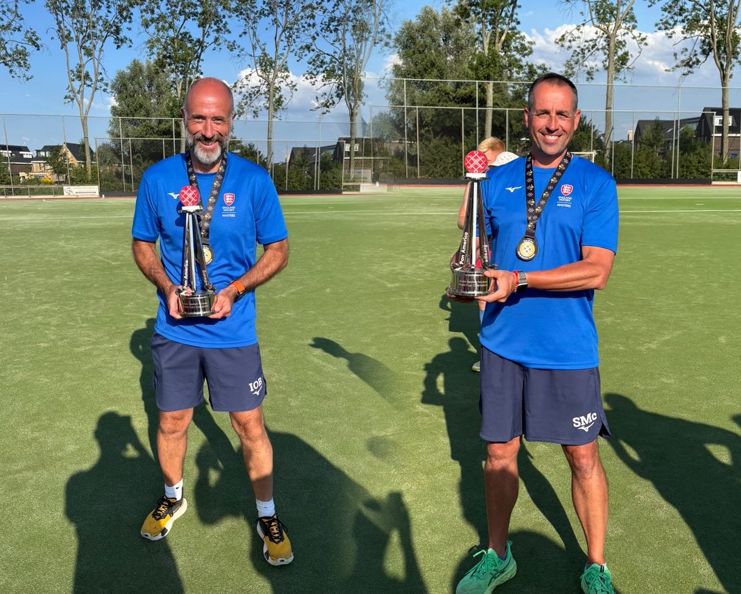Ian and Simon on the pitch with their medals and the championship trophy